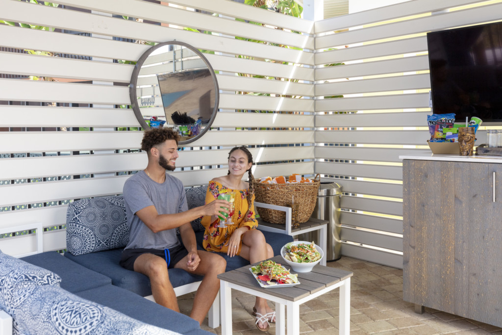 a couple making a toast in their water park cabana with tv