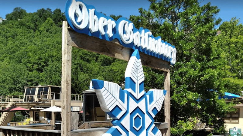 blue and white Ober Gatlinburg entrance side with snowflake and trees in the background during the day