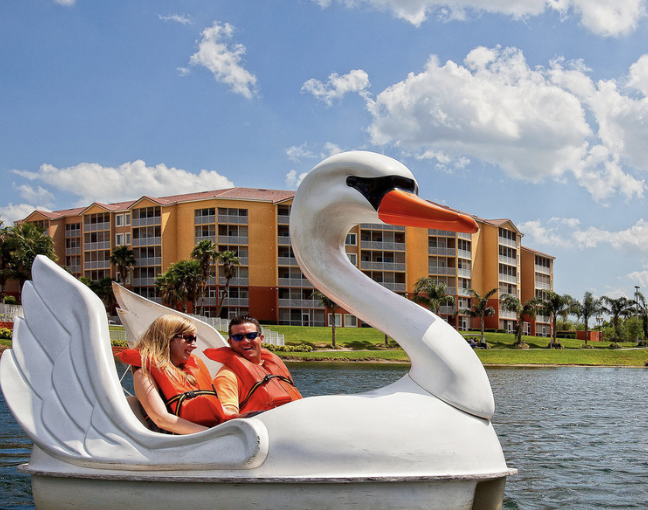 couple in a swan boat with life jackets on the lake at westgate town center resort 