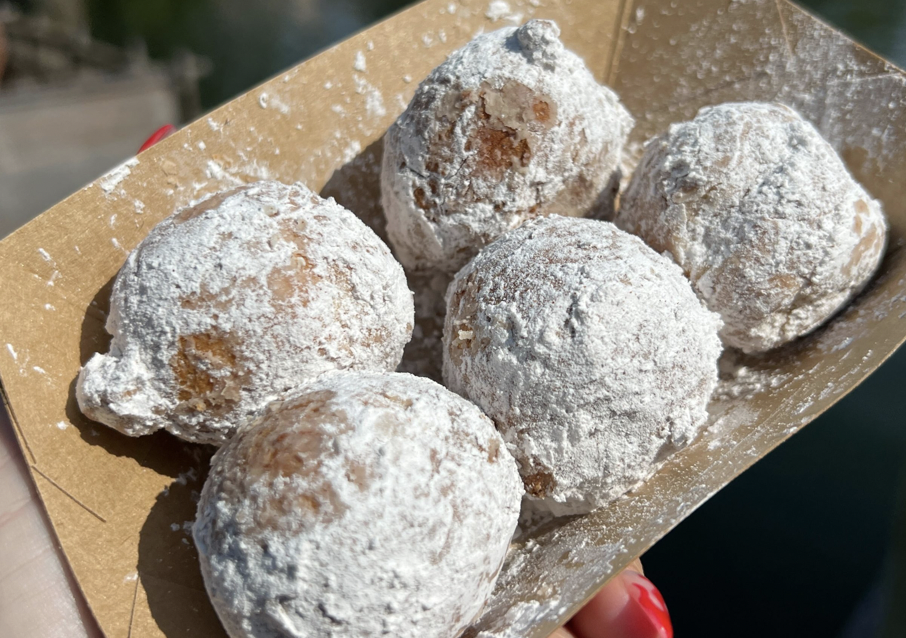 five powdered cinnamon sugar donut holes in a to go tray