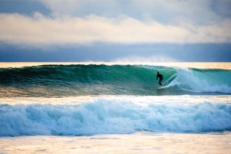 blue waves of the ocean in a wave as a surfer is surving on venice beach in florida
